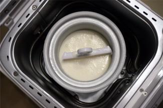 将搅拌均匀的冰淇淋液倒进冰淇淋桶里。