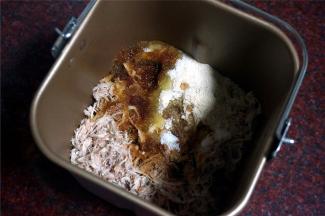 将肉碎放进装了搅拌刀的面包桶里，倒入调味料，稍微拌均匀。