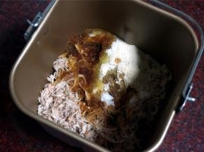 将肉碎放进装了搅拌刀的面包桶里，倒入调味料，稍微拌均匀。