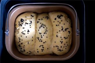 面包发酵至8分满时，表面刷上一层全蛋液，然后撒入少许黑芝麻。