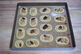 用毛刷刷涂上一层全蛋液，然后按照个人喜好摆放上碧根果，松仁，腰果，杏仁等，并轻压一下。