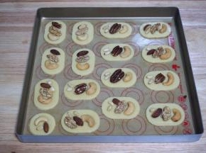 用毛刷刷涂上一层全蛋液，然后按照个人喜好摆放上碧根果，松仁，腰果，杏仁等，并轻压一下。