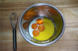往4个蛋黄中，加入52克纯牛奶，40克橄榄油，拌均匀。