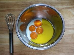 往4个蛋黄中，加入52克纯牛奶，40克橄榄油，拌均匀。