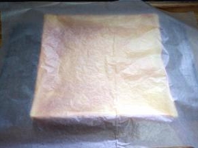 将烤好的蛋糕体倒扣到烤网上冷却，并盖上吸油纸，防止水分散失。