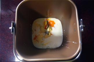 依次将冷藏过的纯牛奶，鸡蛋放入面包桶里，然后放入黄油块，对角分别放入盐和细砂糖。