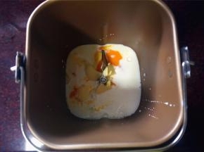 依次将冷藏过的纯牛奶，鸡蛋放入面包桶里，然后放入黄油块，对角分别放入盐和细砂糖。