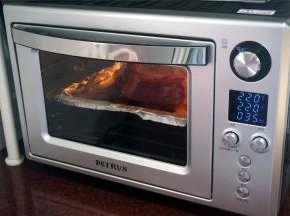 烤箱选择上下大温幅功能，温度为220度，时间35分钟，启动。烤盘垫上锡纸，摆入腌制好的排骨，放入预热好的烤箱中层，开始烘烤。