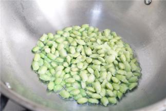 锅里加油，下蒜粒爆香再将青豆下锅。