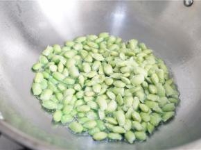 锅里加油，下蒜粒爆香再将青豆下锅。