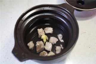 再将焯好的排骨加姜片在炖锅里，并加入清水。