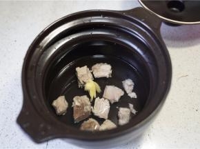 再将焯好的排骨加姜片在炖锅里，并加入清水。