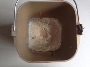 面包桶内依次放入牛奶、蛋液，对角放糖和盐，再放奶粉、面粉，在面粉顶端放入酵母。启动面包机的和面程序15分钟