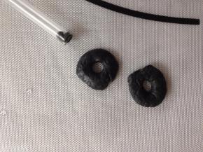 黑色面团弄成两个小小的圆形，中间部分用吸管压出小孔