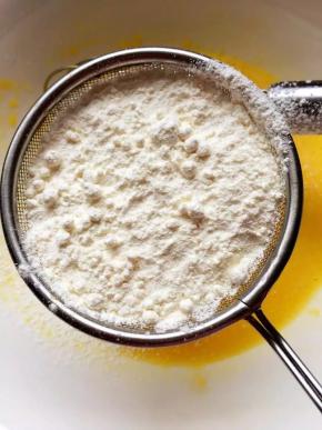 3、拌好后的蛋黄液里筛入低粉，用翻拌和切拌的方法拌匀，不要划圈拌，以免起筋