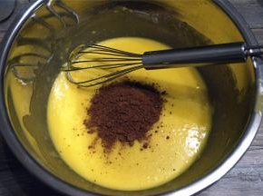 把剩下的可可粉加入到大盆的蛋黄糊中，拌均匀。