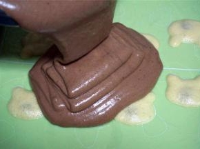 将可可蛋糕糊倒到图案上，震荡出大气泡，表面抹平。