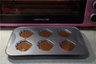 预热好烤箱，将蛋糕糊挤在贝壳模里。