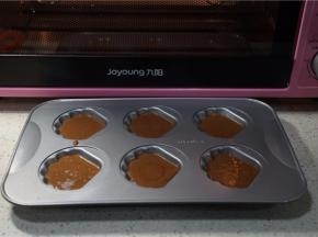 预热好烤箱，将蛋糕糊挤在贝壳模里。