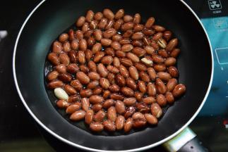 冷油冷锅，放入花生仁小火爆香