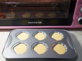 预热好烤箱，将蛋糕液挤在贝壳模里。