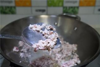 将菜脯及肉都切丁备用，锅里加油将肉丁下锅煸香。
