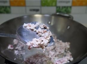 将菜脯及肉都切丁备用，锅里加油将肉丁下锅煸香。