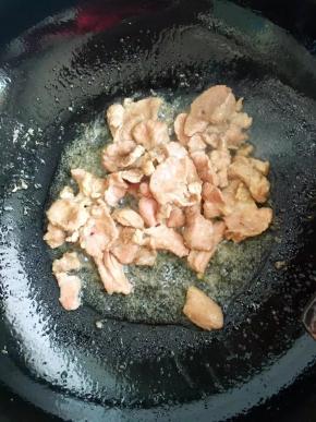 5、锅中放油倒入五花肉炒至表面焦黄