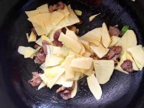 7、倒入笋片翻炒均匀