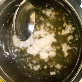 4、用饭勺将浮沫搅一下，使浮上来的豆扁下沉