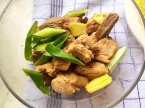 3、排骨中加入半勺盐、料酒、生抽、姜片和葱段腌制半小时