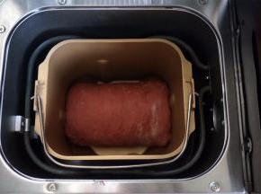 将面团卷起，放入面包机桶内。