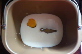 将牛奶，鸡蛋放入面包桶里。