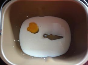 将牛奶，鸡蛋放入面包桶里。