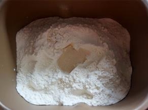 加入高筋粉，在粉中央挖一个凹位放入酵母。