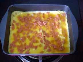 热锅下油，倒入火腿蛋液，煎熟，然后对半分成两份。