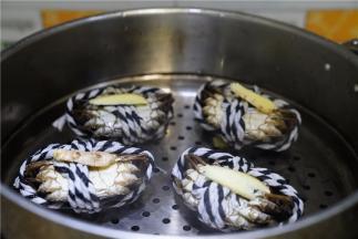 将刷好的闸蟹倒扣放在蒸格上，再放上姜片。蒸十分钟左右至蟹熟。