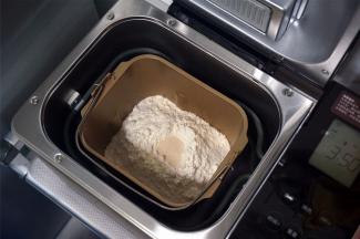 根据食谱提供的参考配方称量食材。按照先液体后固体的顺序将食材放入面包机桶内。