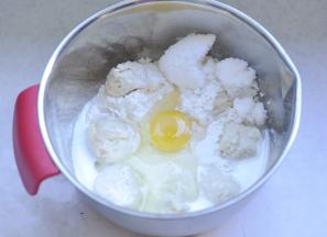 1、面粉里依次放入鸡蛋、牛奶、白糖，把提前发酵好的中种面撕开小块放入。