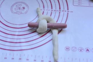 13、香肠放n型面上，把2个头搭过香肠