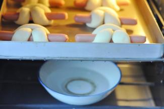 16、烤箱底层放碗热水二发20分钟左右，将小兔刷上玉米油，包括香肠上，防止香肠烤干，上下火180度中层 20分钟，烤的上色后盖锡纸。