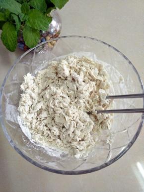 把面团用料全部倒入碗中，用筷子挑成絮状。