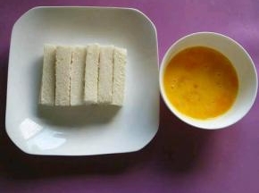 鸡蛋打散在碗里，加一点盐搅拌均匀，馒头切小条。