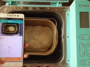 将面包桶放入到东菱4706W面包机内。打开手机阿里智能APP，连接手机，选择普通和面10分钟