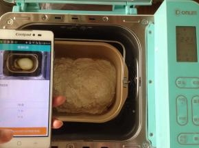 将面包桶放入到东菱4706W面包机内。打开手机阿里智能APP，连接手机，选择普通和面10分钟