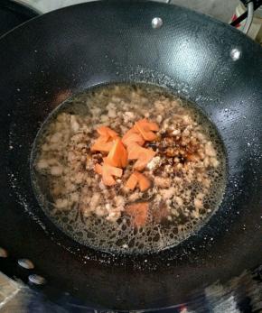 加入一小碗的热水，生抽，盐和切成心形的胡萝卜，烧个2分钟。