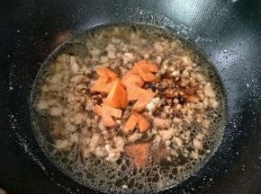 加入一小碗的热水，生抽，盐和切成心形的胡萝卜，烧个2分钟。