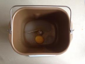 将水和蛋放进面包桶内，对角放糖和盐