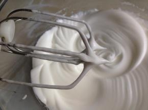 将45克糖分三次加入到蛋清里，将蛋白打至短小的尖角