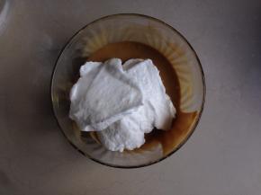 取三分之一打发好的蛋白加入到蛋黄糊里，由下往上翻拌均匀